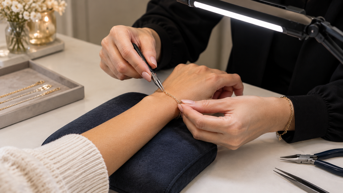 Gold permanent jewellery bracelet being fitted onto a wrist in Bolton