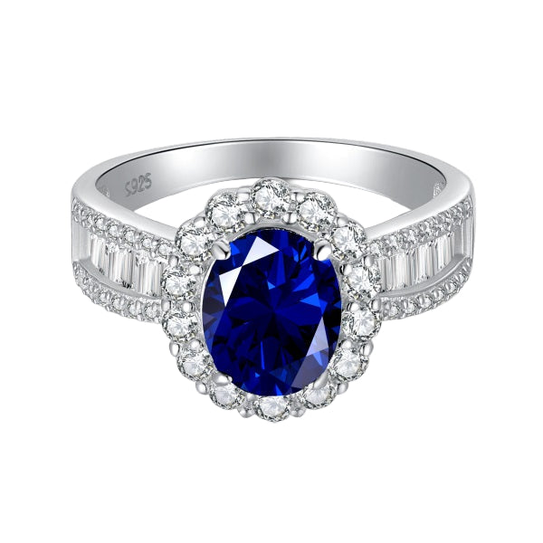 An elegant sterling silver ring featuring an oval blue zircon stone with smaller clear stones around it, showcasing a traditional Indian royalty-inspired design.