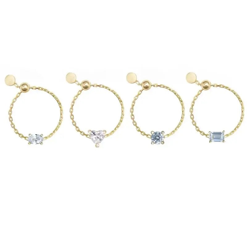 Four gold chain rings with different gemstone designs on a white background
