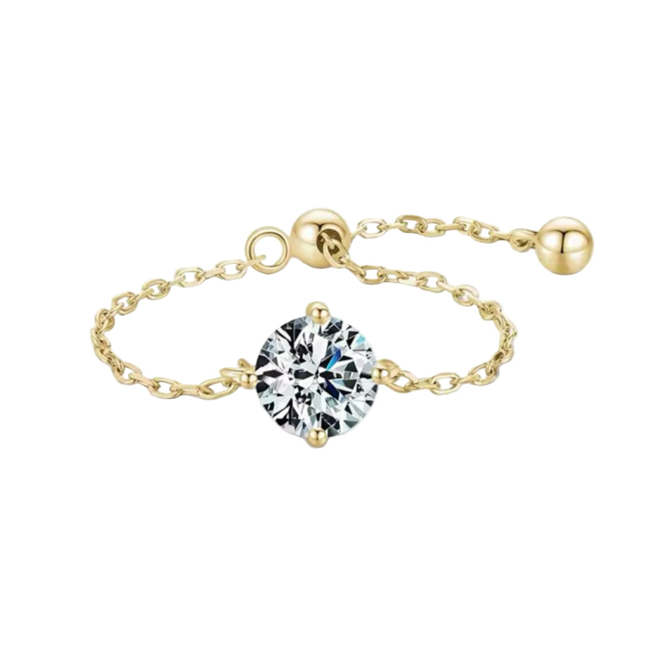 An adjustable sterling silver ring with a gold/silver color, featuring a single clear cubic zirconia stone, linked to a chain of gold-tone beads.