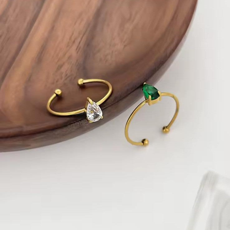 Gold rings with diamond and emerald on a white background