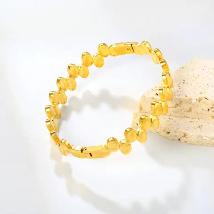Gold beaded bracelet on a light background