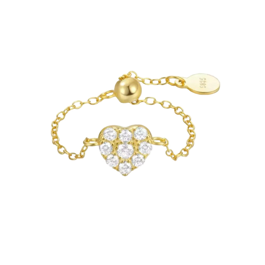 A gold-colored adjustable chain ring with a sparkling diamanté heart centerpiece.