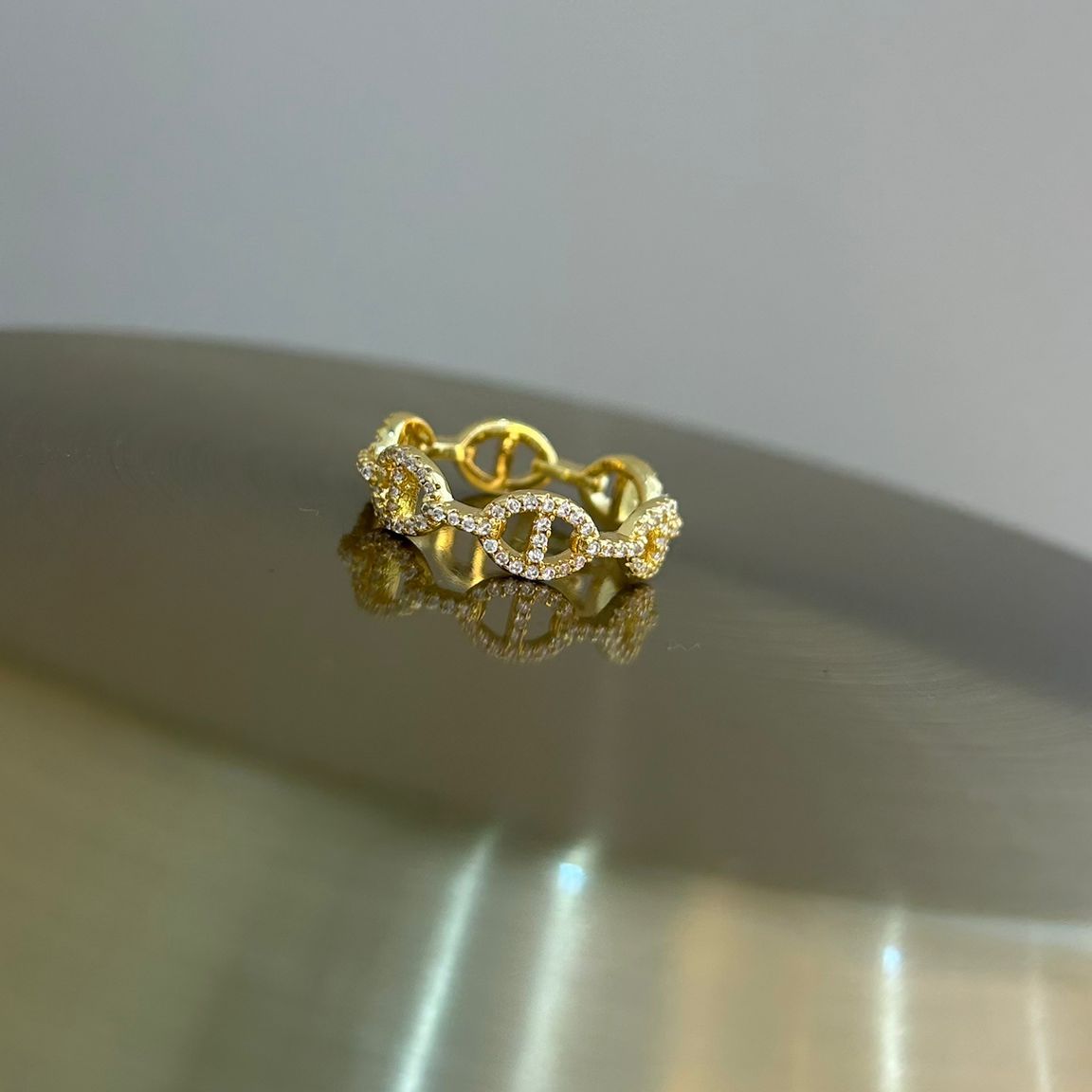 Gold ring with diamond accents on a blurred background