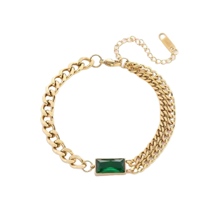 Gold chain bracelet with a green gemstone on a white background