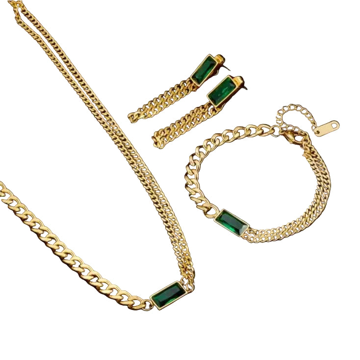 Gold jewelry set with green gemstones on a black background