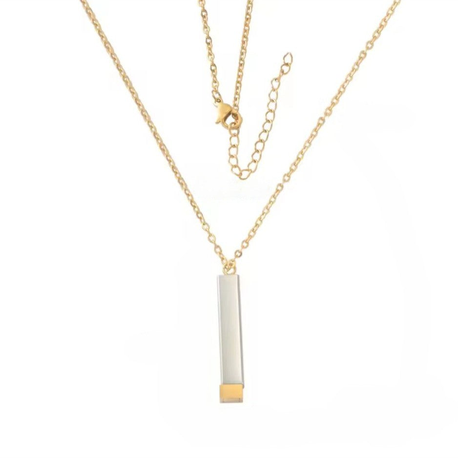 Gold necklace with a vertical bar pendant on a white background