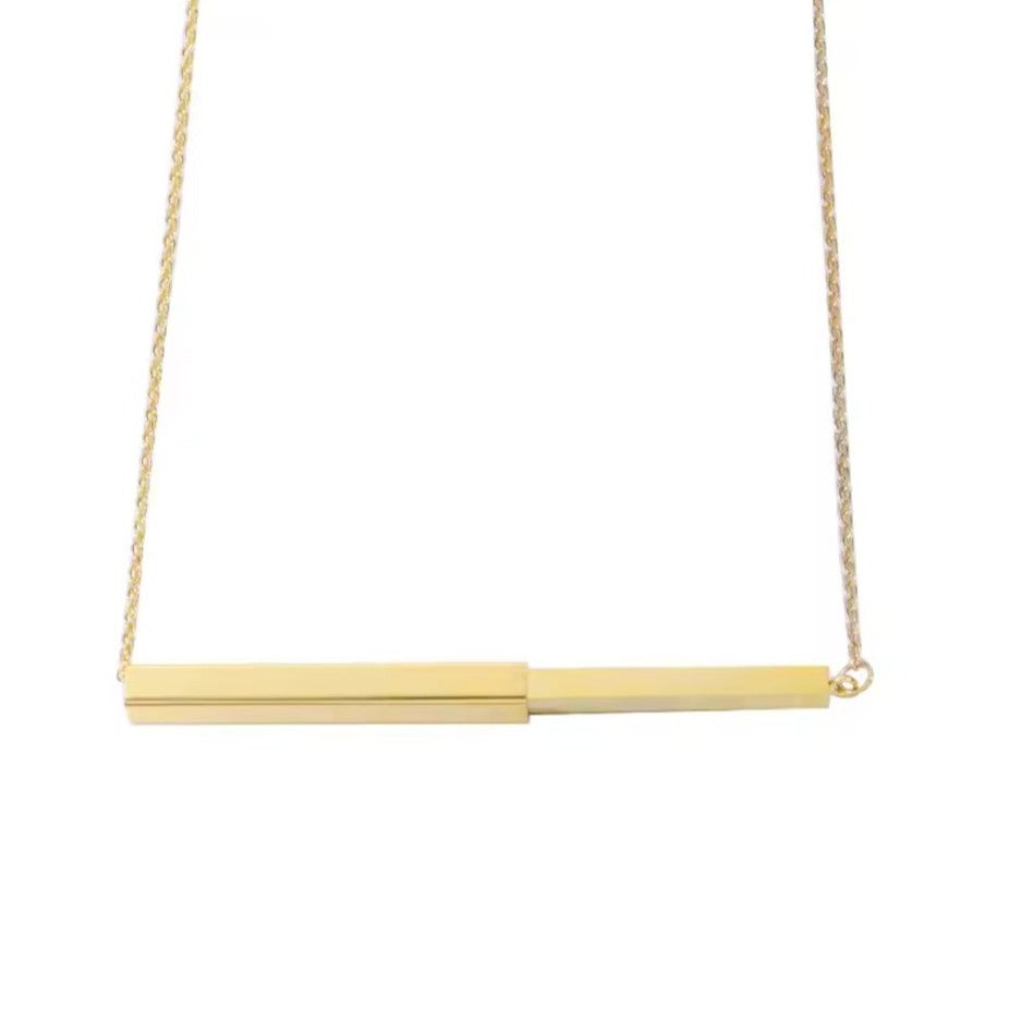 Gold necklace with a bar pendant on a white background