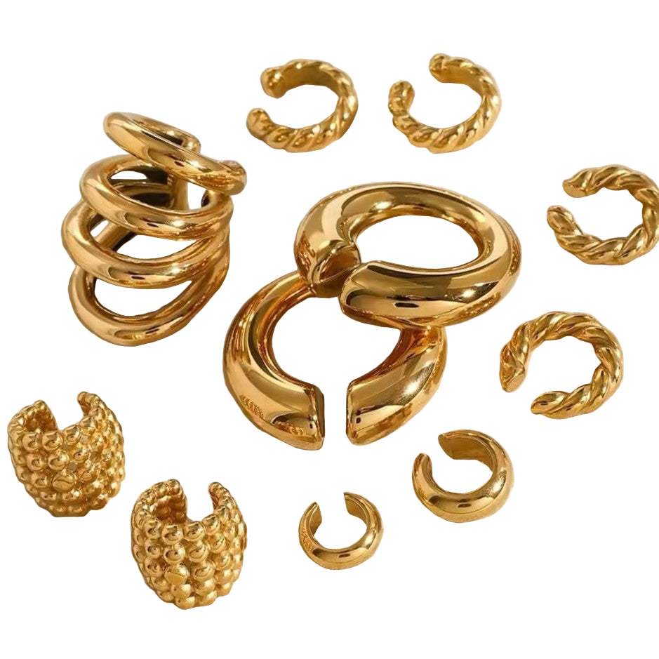 A collection of gold-colored ear cuffs with varying designs displayed on a neutral background.