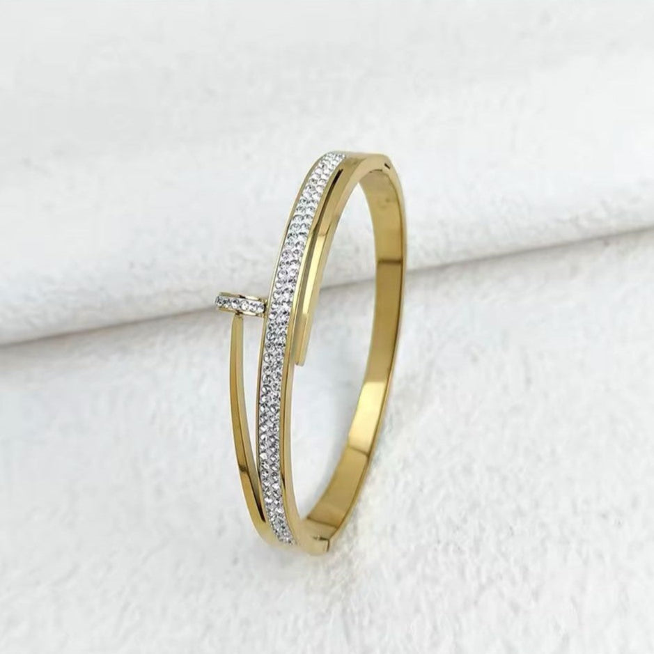 Gold bracelet with clear stones on a white background