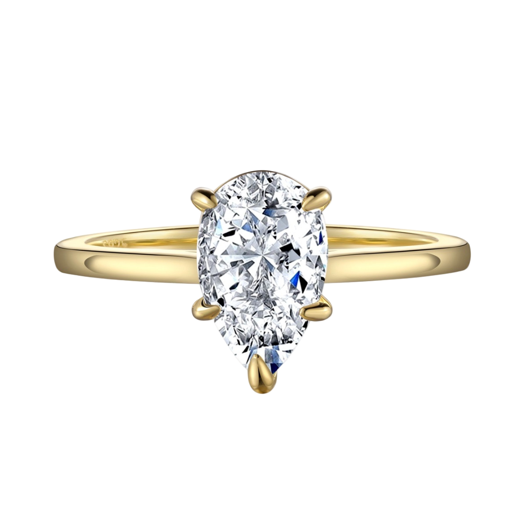 A gold-colored ring featuring a pear cut cubic zirconia set in a six-prong setting.