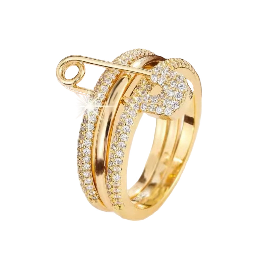 A gold-colored PinLock double band stainless steel ring with a safety pin design encrusted with dazzling stones.