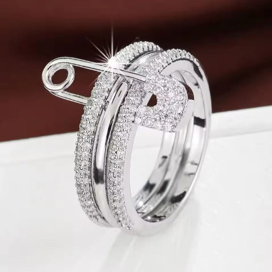 A silver-colored PinLock double band stainless steel ring with a safety pin design encrusted with dazzling stones.