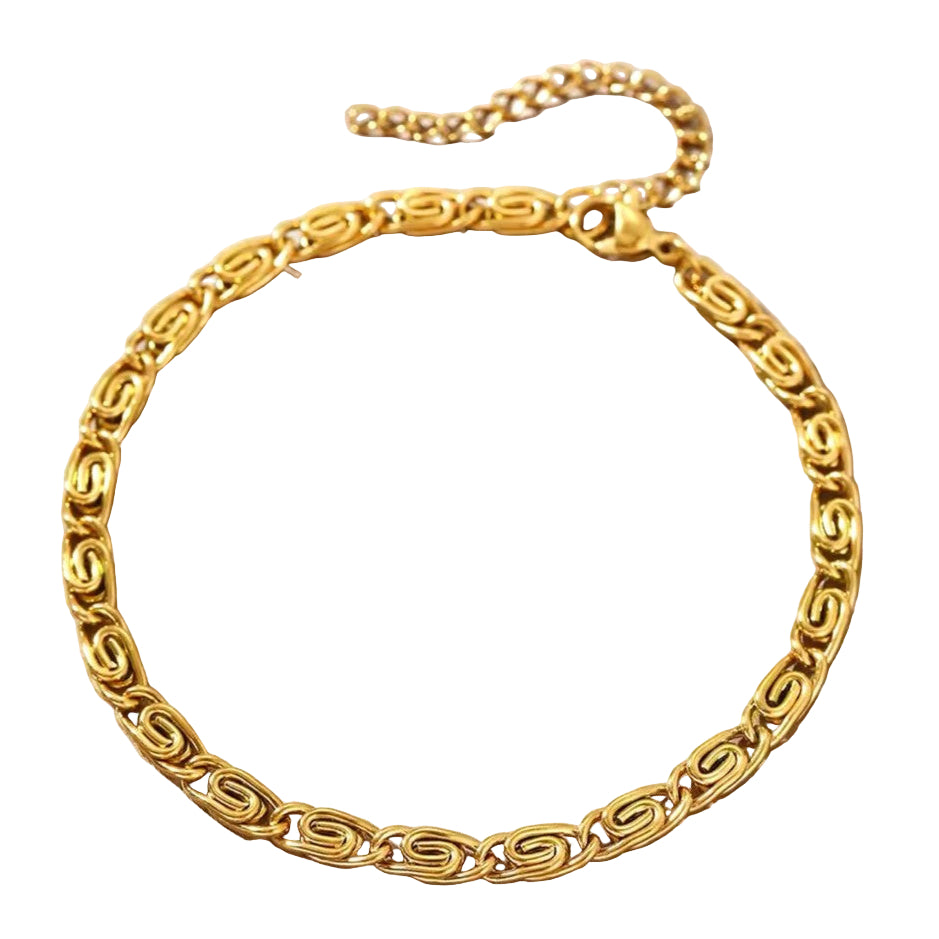 A gold-colored stainless steel bracelet with a geometric pattern, displayed on a neutral background.