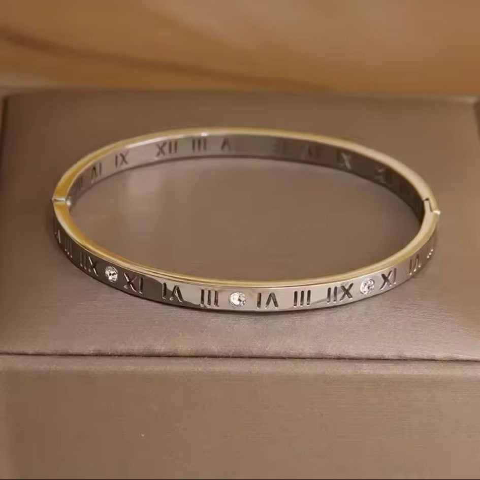 A Roman Style Stainless Steel Classic Bangle – Silver colored with white stones on a neutral background.