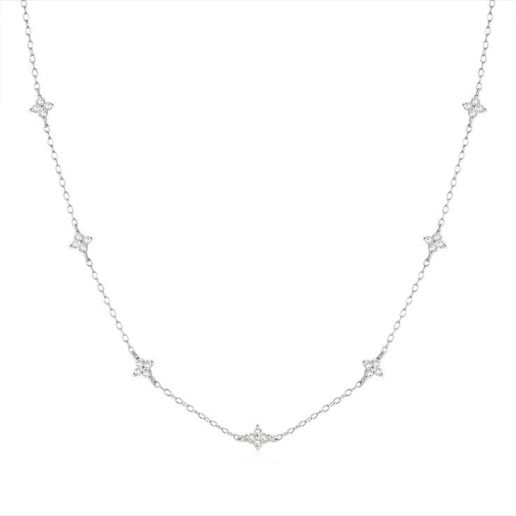 A sterling silver necklace featuring a series of small dainty flower-shaped pendants, with a silver color scheme.