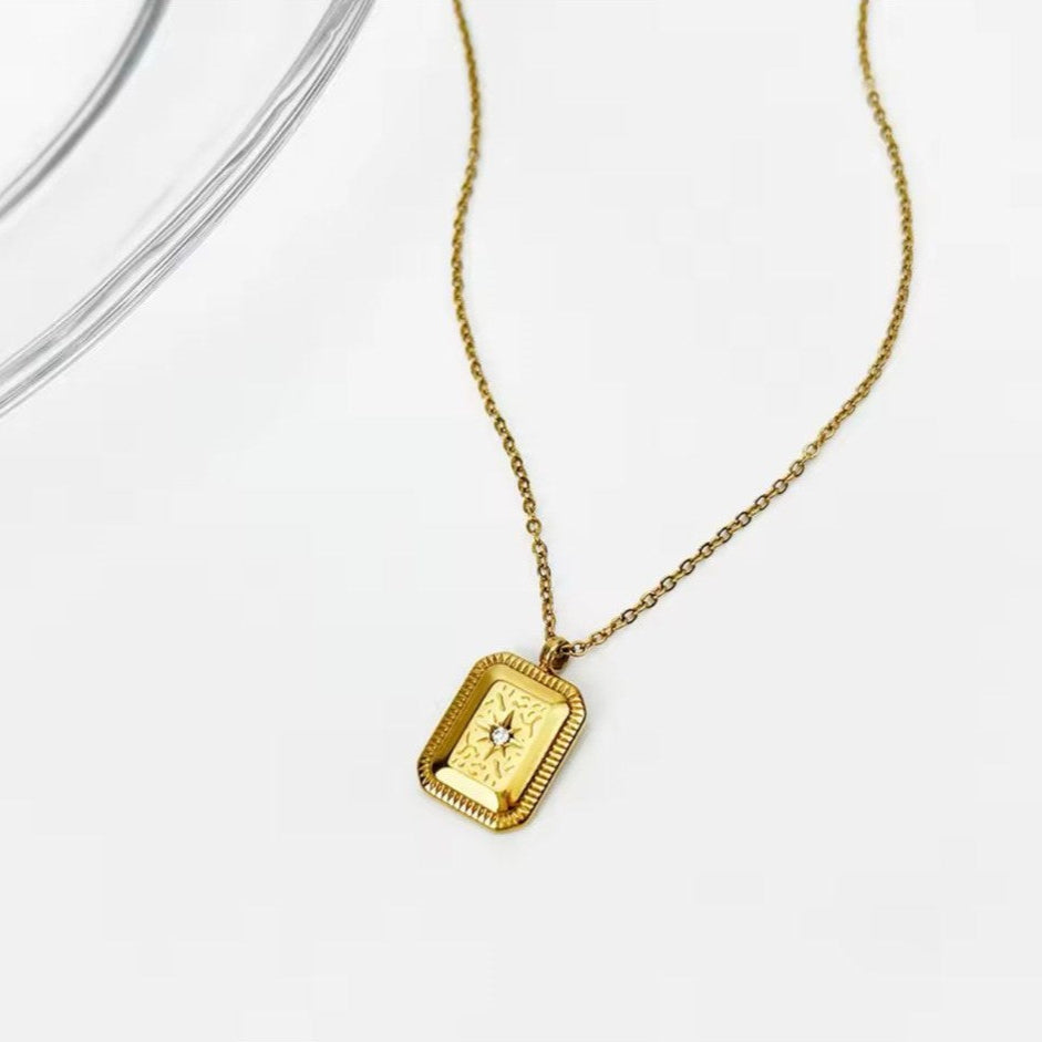 A vintage geometric charm necklace with titanium steel square pendants, gold-plated, displayed against a white background.