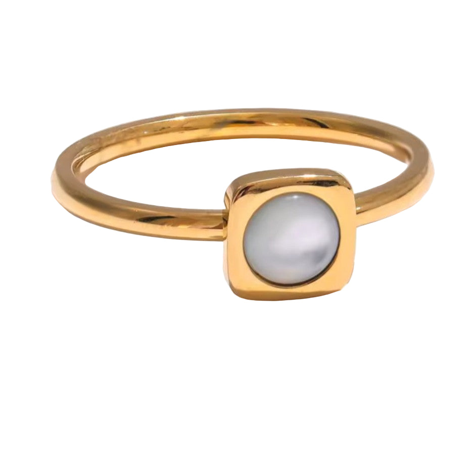 Gold ring with a central gemstone on a white background