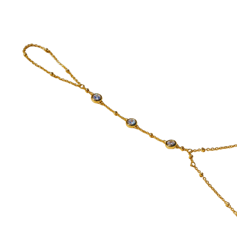 A delicate gold chain bracelet with bezel-set crystal accents, displayed on a white background.