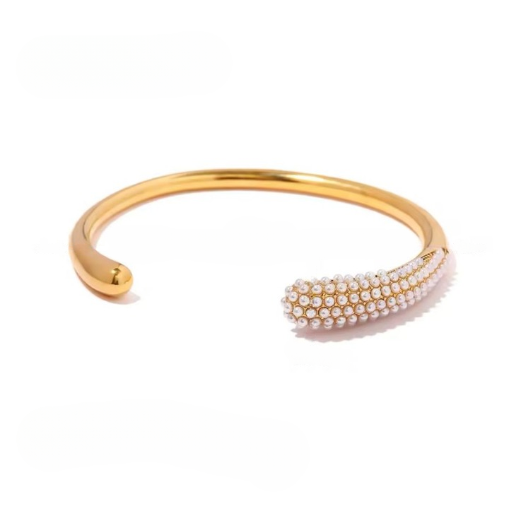 A gold-colored stainless steel bracelet with pearl adornments, displayed against a white background.