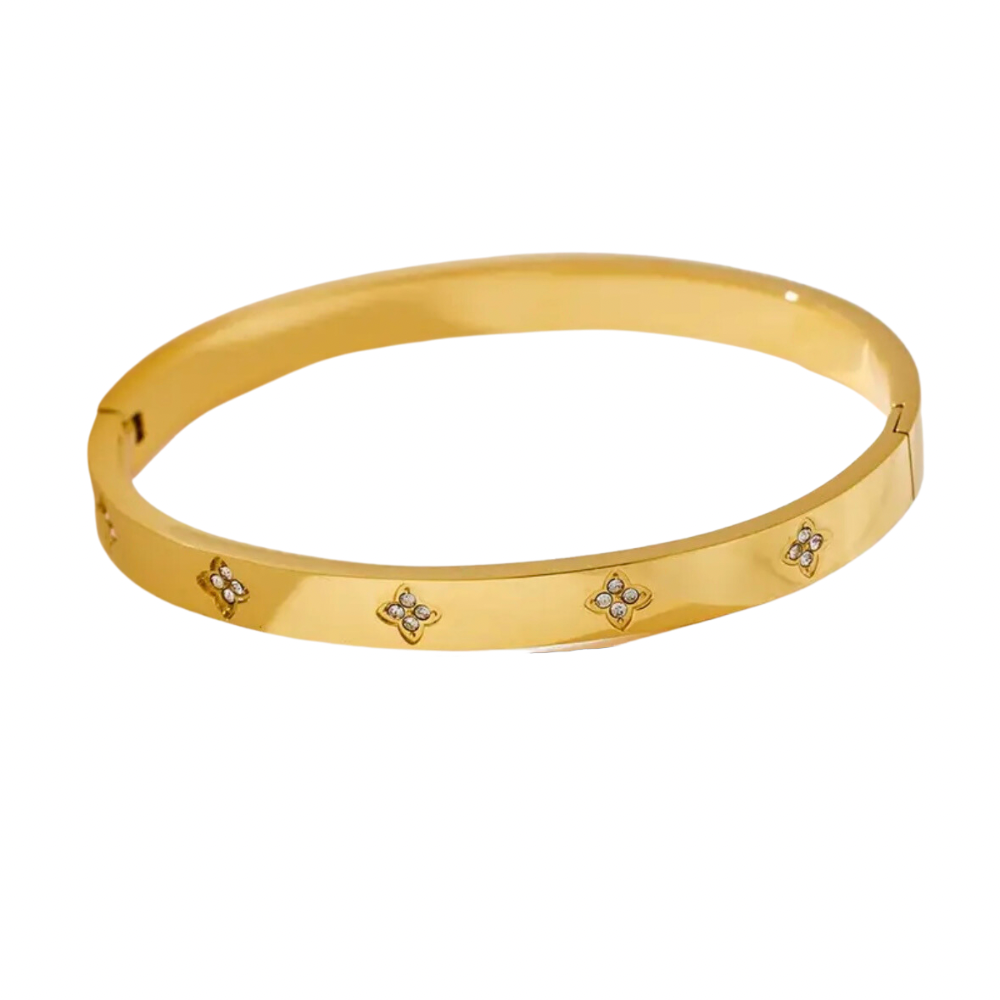 A gold stainless steel bangle bracelet with flower accents.