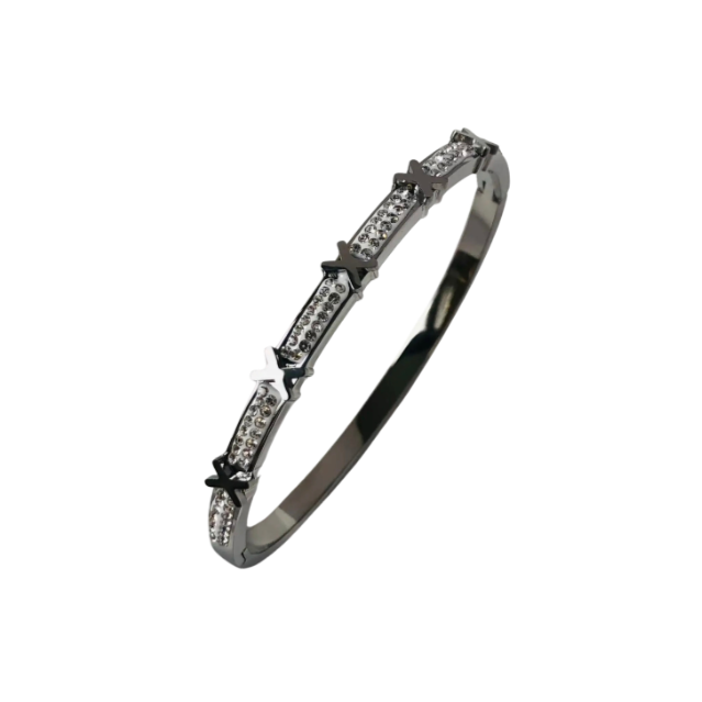 A silver stainless steel bangle bracelet with intricate designs and sparkling accents.