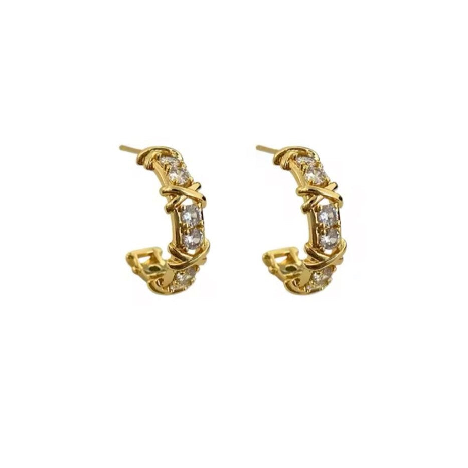 Gold hoop earrings with diamond accents on a white background
