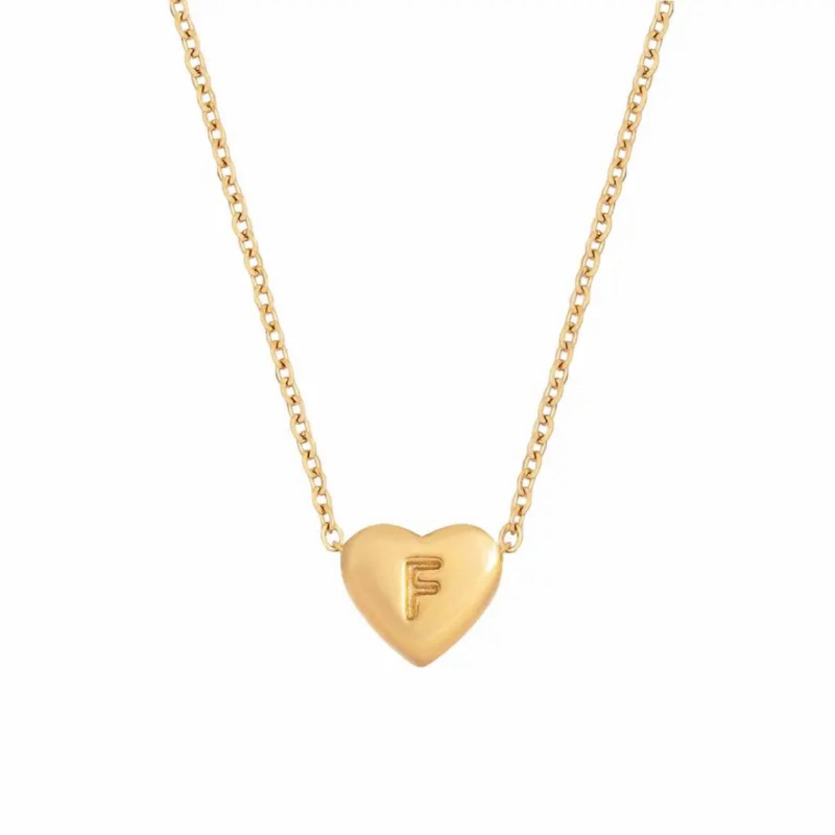 A gold-colored heart initial necklace with the letter 'F' on a chain.