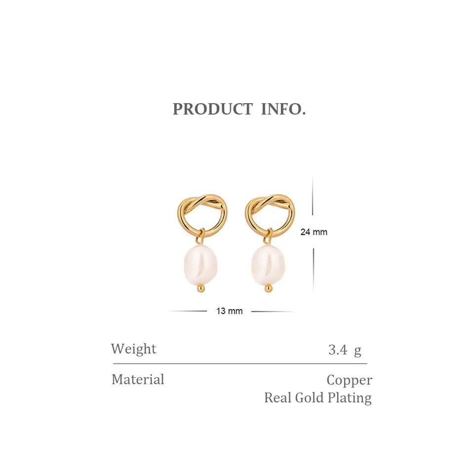 A pair of gold-plated hoop earrings with white pearls dangling from them.