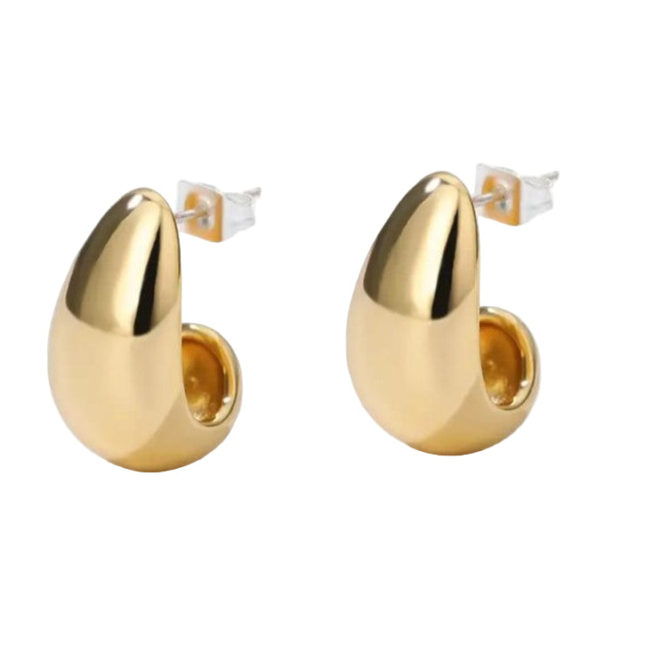 A pair of gold-colored, curved hoop earrings on a white background.