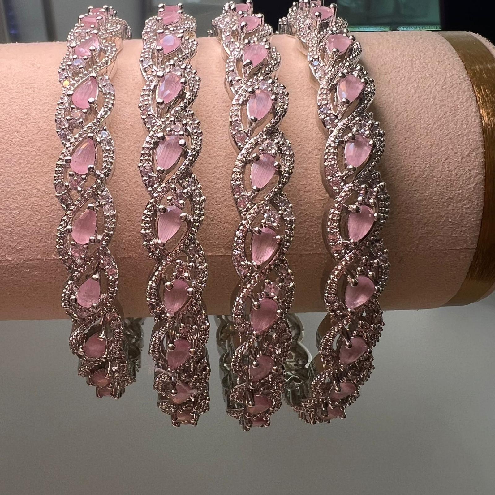 Four pink gemstone bracelets on a mannequin arm against a neutral background.