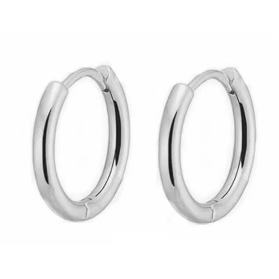 A pair of silver-colored huggie hoop earrings made of stainless steel.
