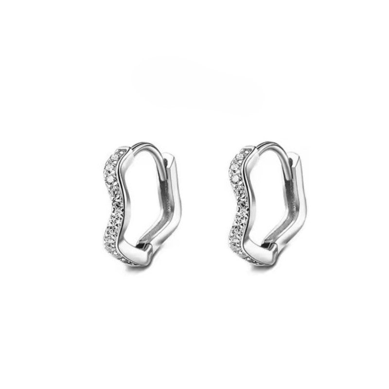 A pair of silver-colored huggie hoop earrings with a wave pattern design, made from stainless steel.