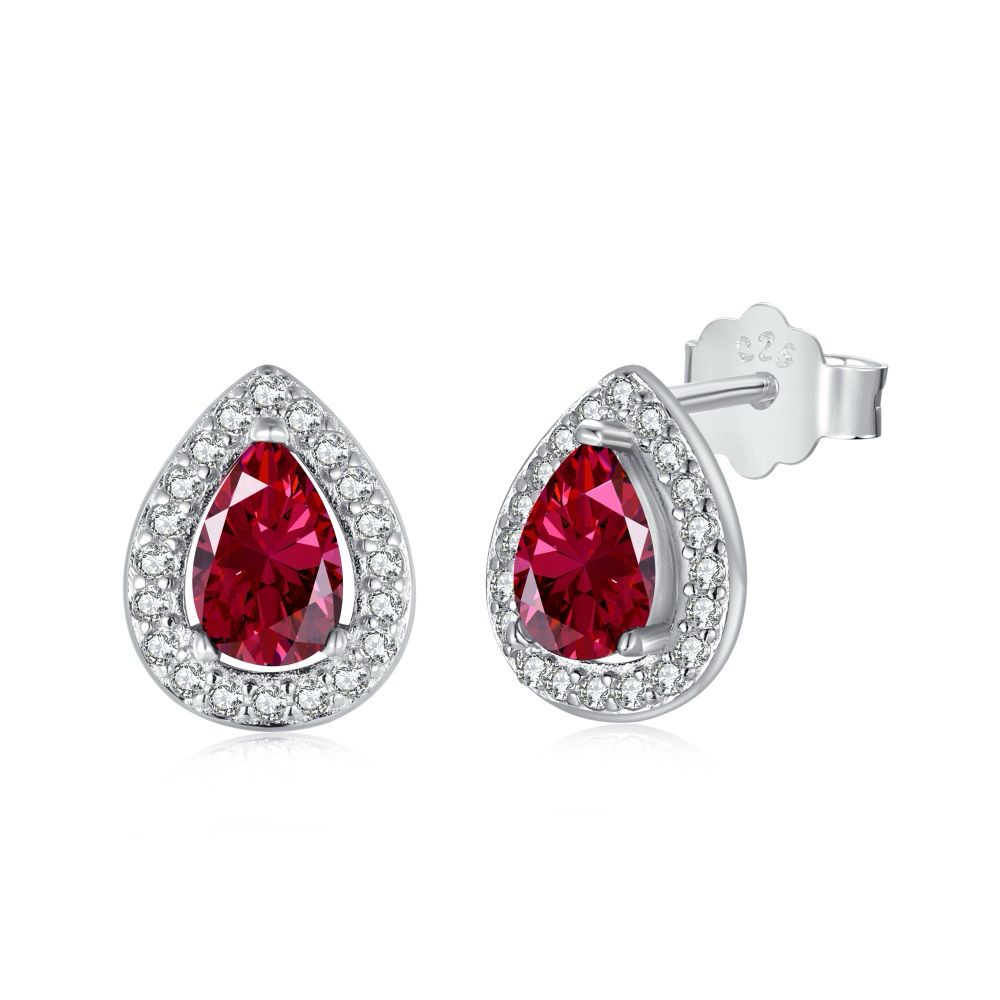 A pair of pear-shaped stud earrings with red main stones and clear accent stones set in sterling silver bands.