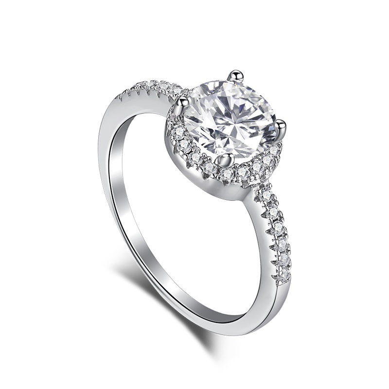 A sterling silver engagement ring with a central cubic zirconia stone surrounded by smaller clear stones, featuring a classic six-prong setting.
