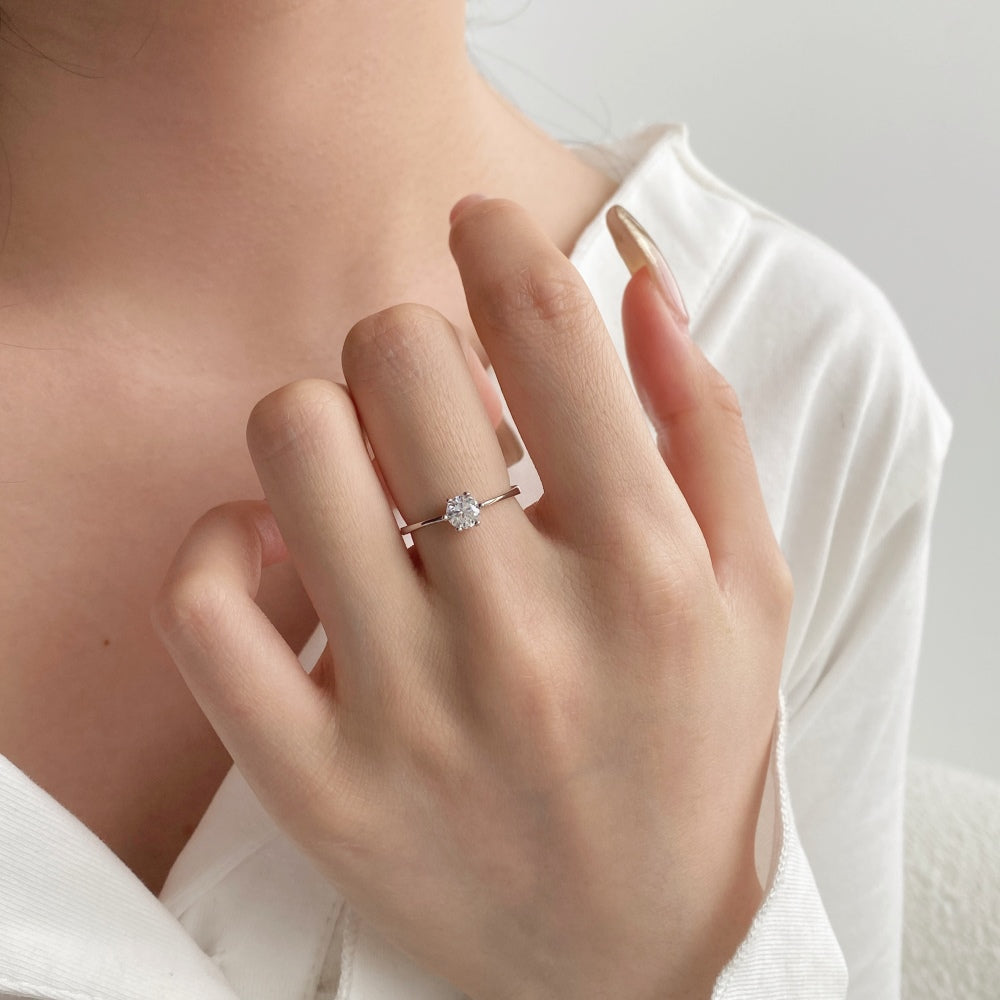 A silver-colored adjustable ring featuring a round 0.5 ct zirconia main stone set in a silver-colored band.