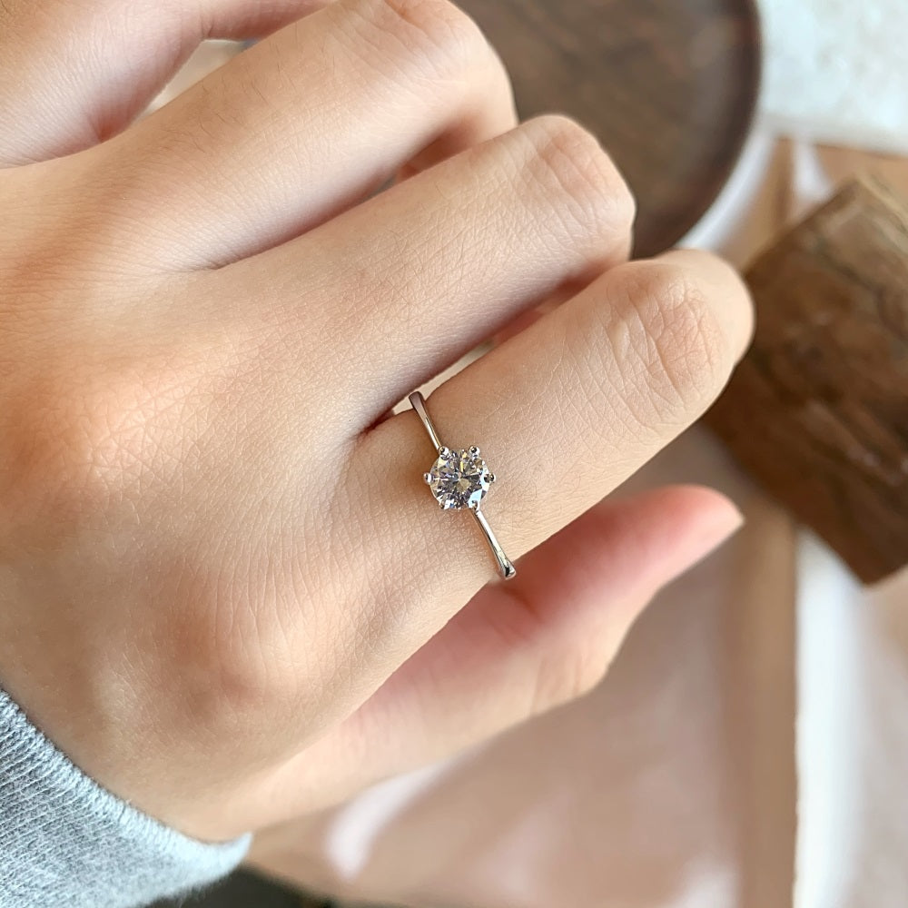 A silver-colored adjustable ring featuring a round 0.5 ct zirconia main stone set in a silver-colored band.