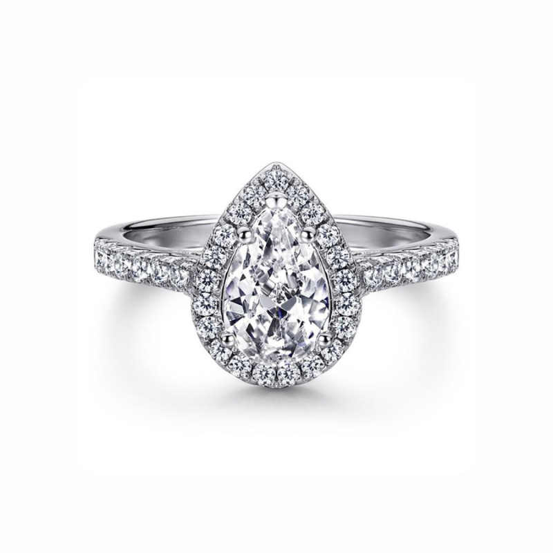 A sterling silver ring featuring a pear-shaped central stone with a halo of smaller stones around it, set on a white background.