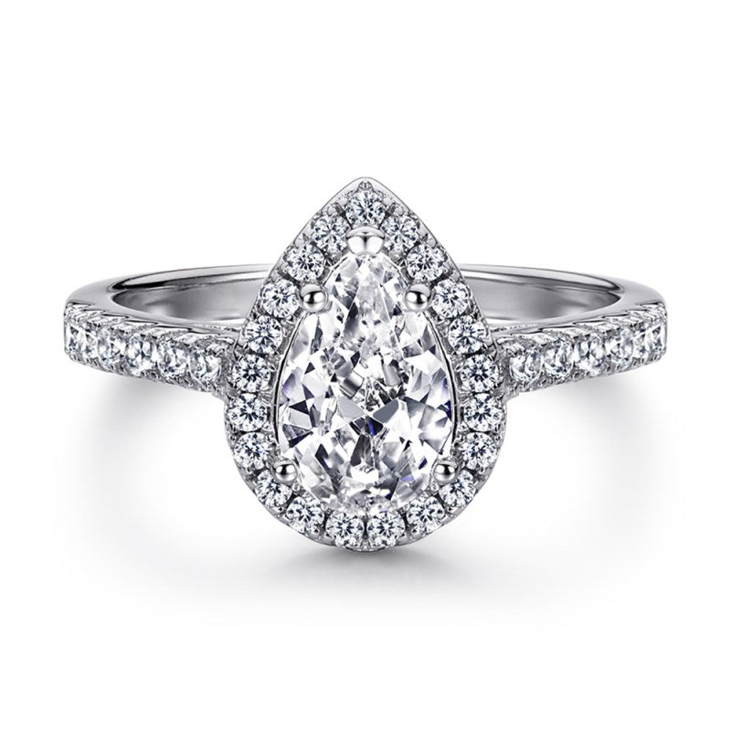 A sterling silver ring featuring a pear-shaped central stone with a halo of smaller stones around it, set on a white background.