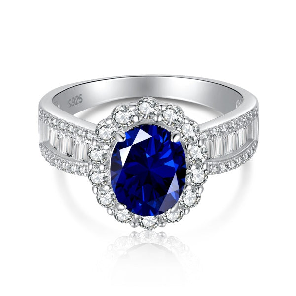 An elegant sterling silver ring featuring an oval blue zircon stone with smaller clear stones around it, showcasing a traditional Indian royalty-inspired design.