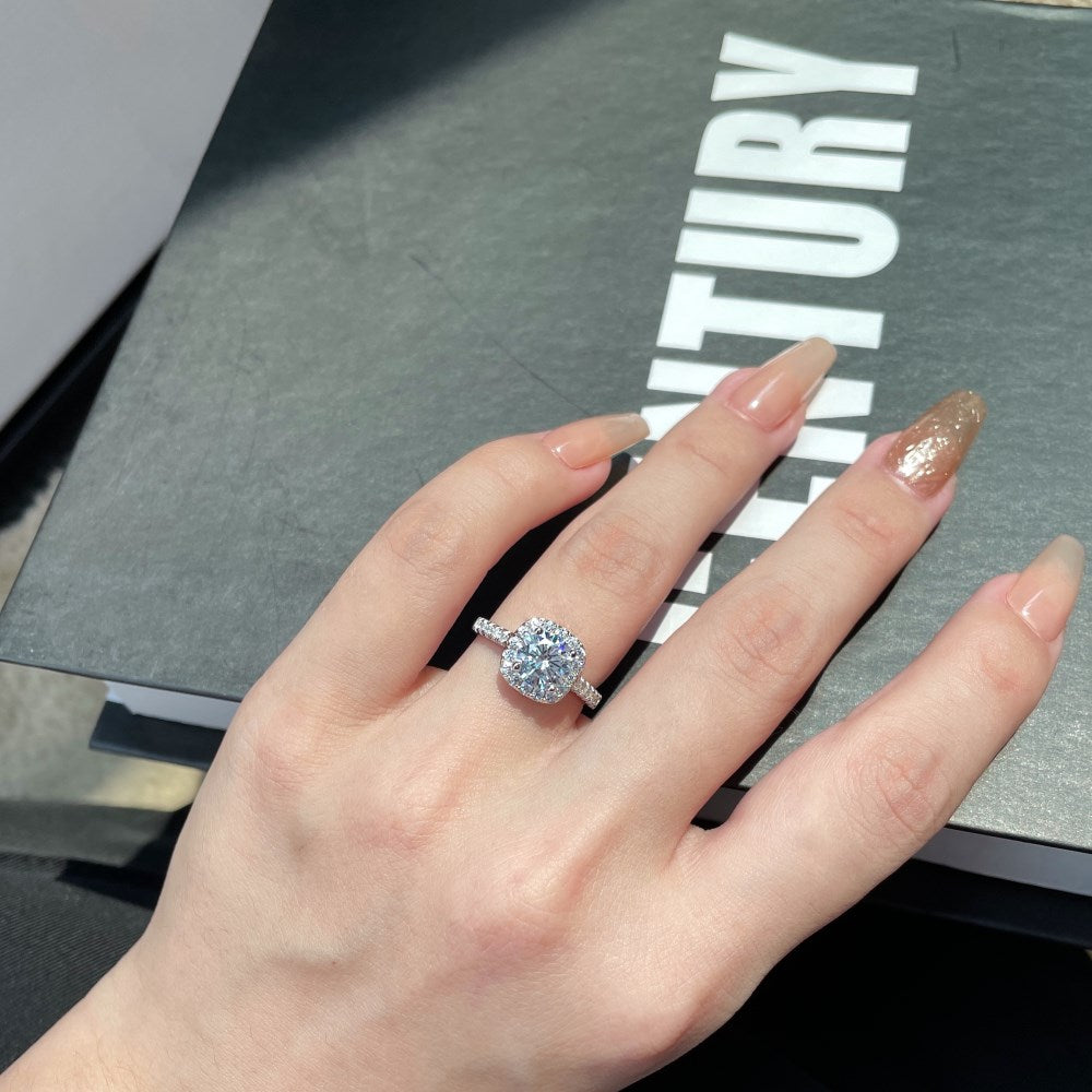 An elegant sterling silver ring featuring a round clear zircon stone with smaller clear stones around it, showcasing an inspired design.