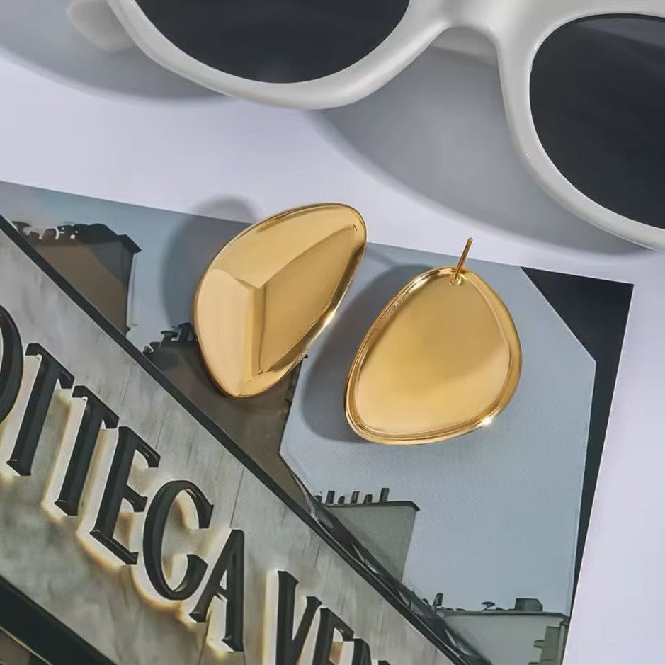 Pair of gold earrings on a cover background