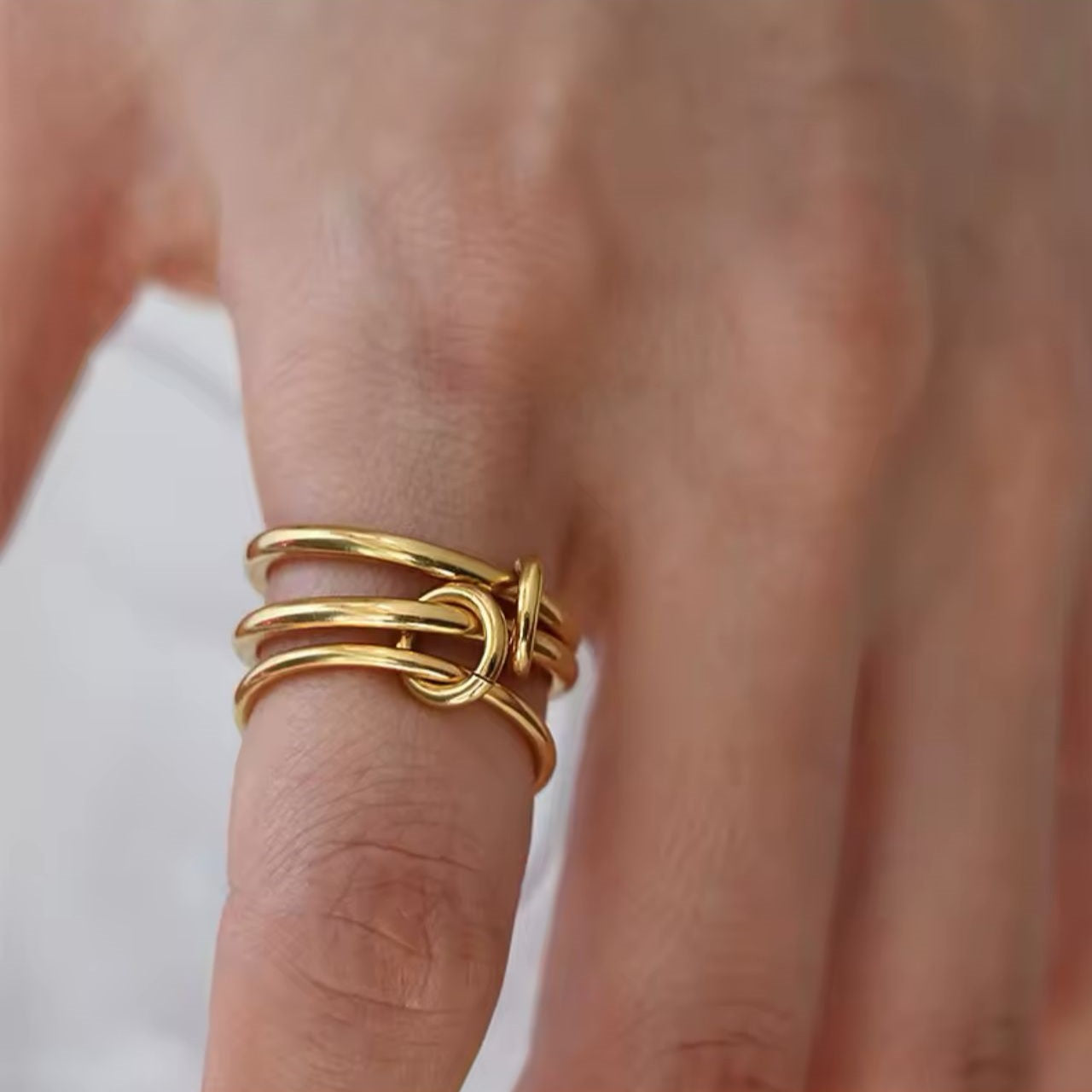A ring with set of three interlocking rings with gold colors, crafted from 18K gold plated stainless steel.