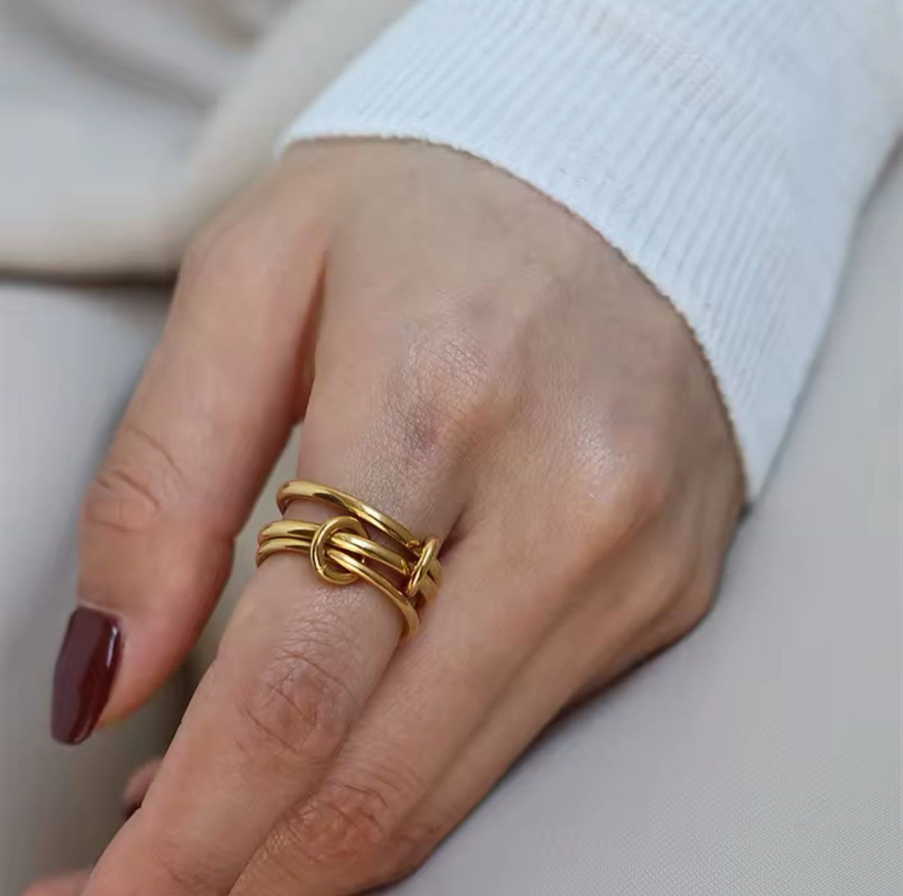 A ring with set of three interlocking rings with gold colors, crafted from 18K gold plated stainless steel.