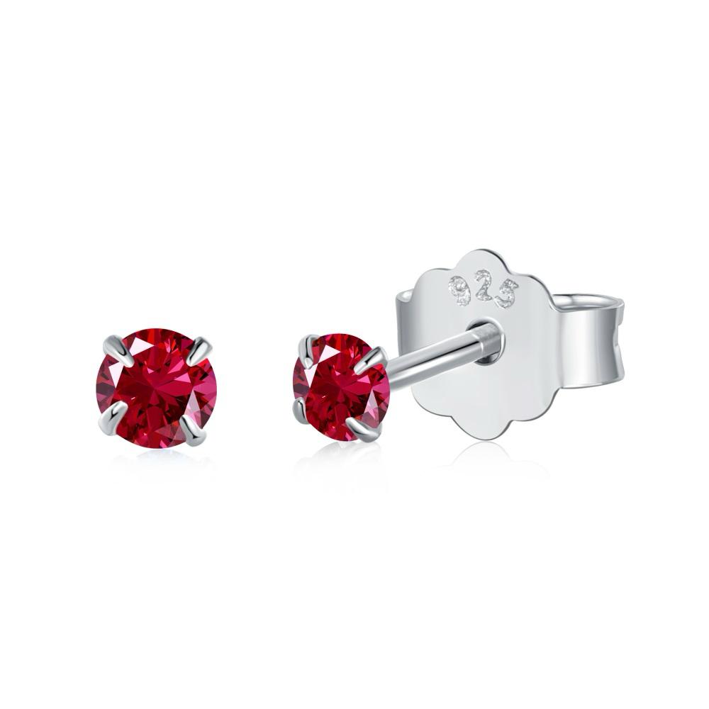 A pair of Luxe Stud Earrings with red stones on a white background.