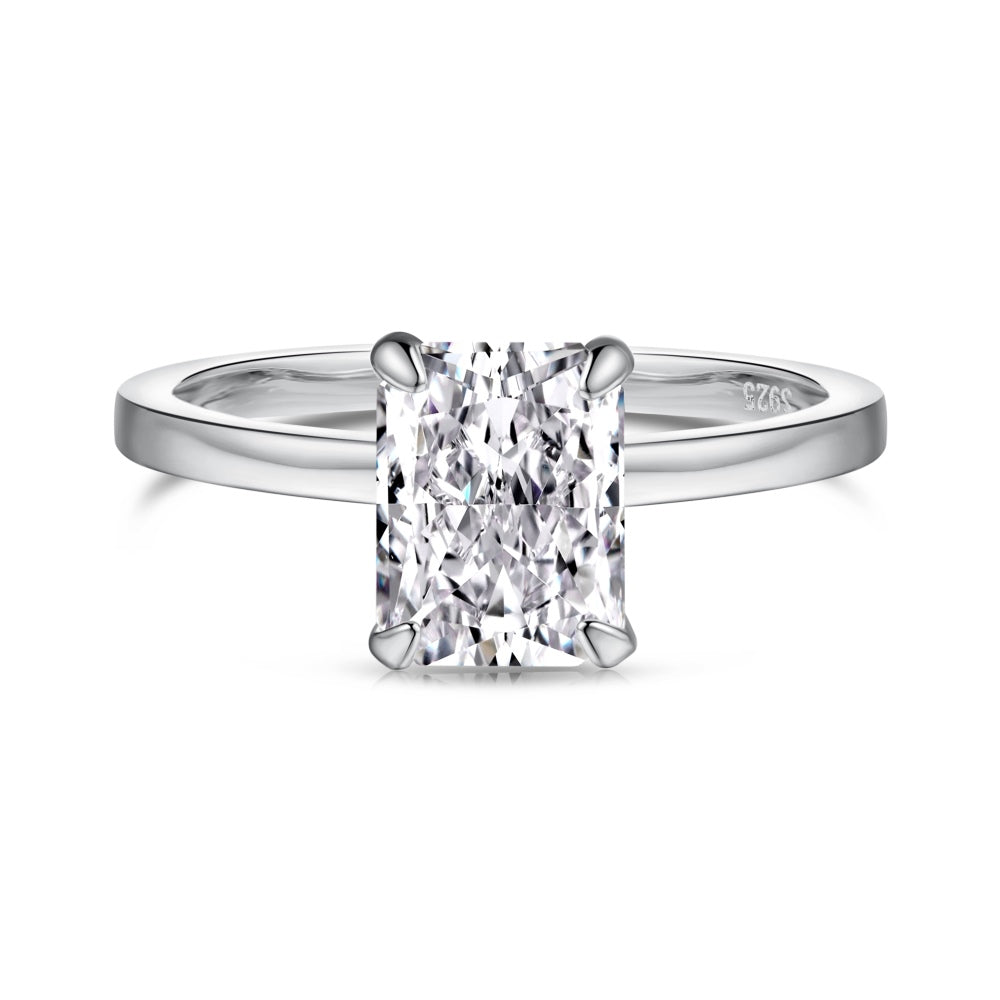A silver band ring with a single rectangle-shaped clear stone set in a metallic setting.
