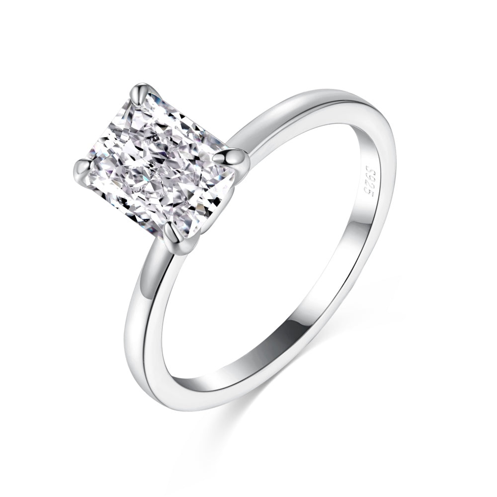 A silver band ring with a single rectangle-shaped clear stone set in a metallic setting.