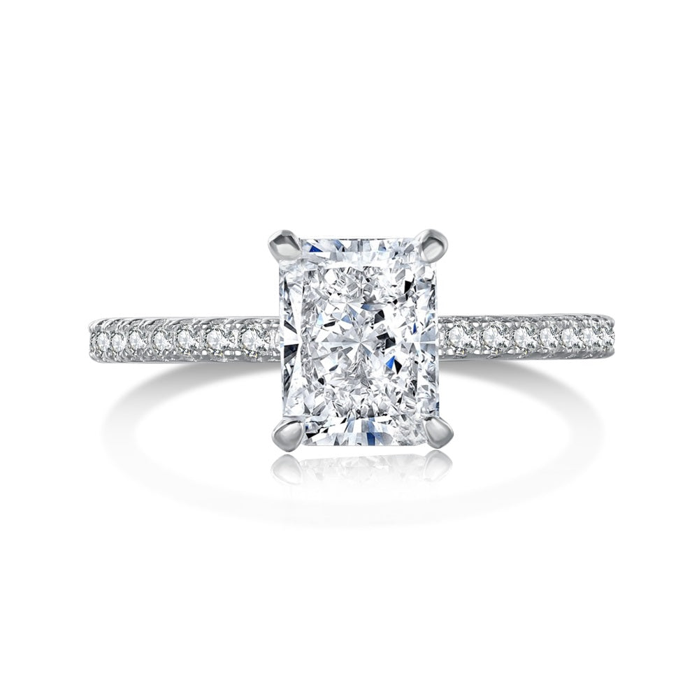 A rectangular radiant cut central diamond with smaller stones set in a silver band