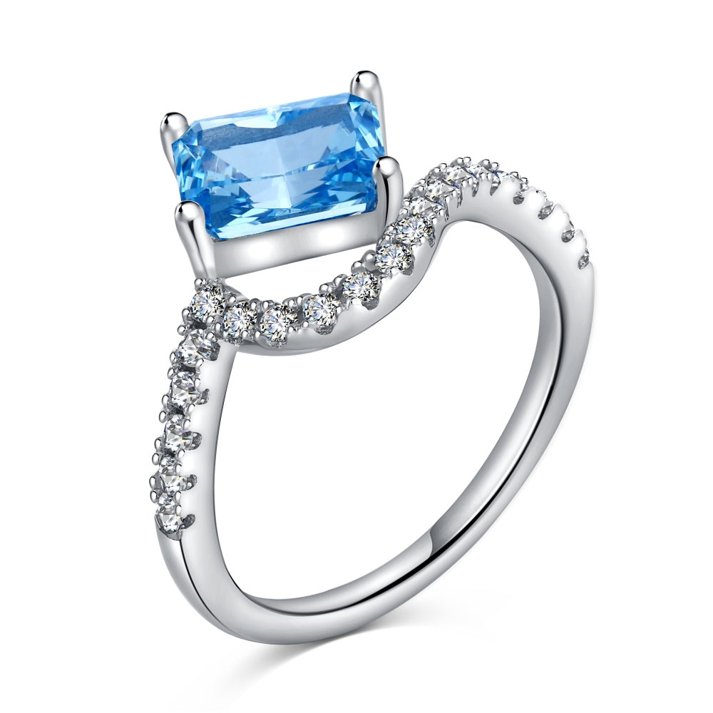 A sterling silver ring featuring a main stone (blue-toned), shaped as a rectangle and set with smaller round diamonds.