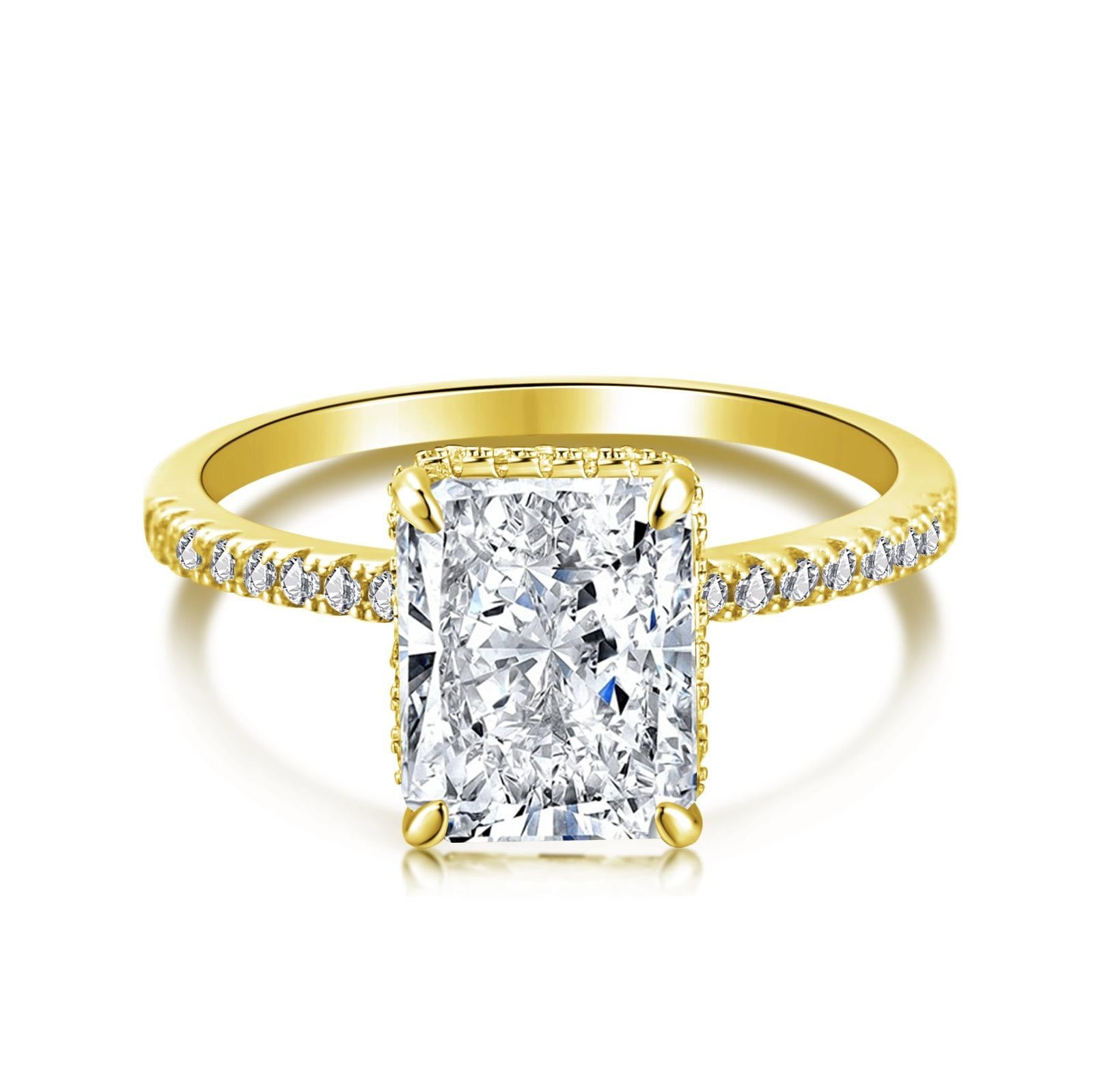 A gold-colored band engagement ring featuring a large rectangle-shaped central stone with smaller stones around it